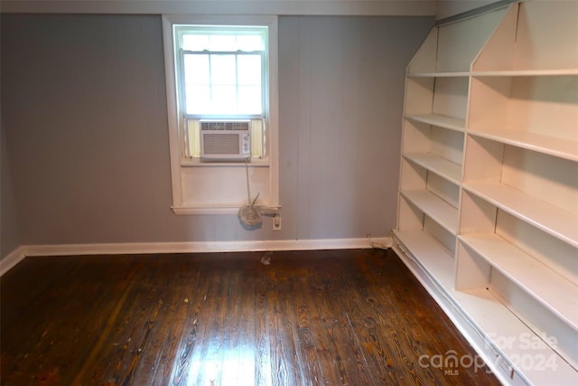 spare room featuring cooling unit and dark hardwood / wood-style floors