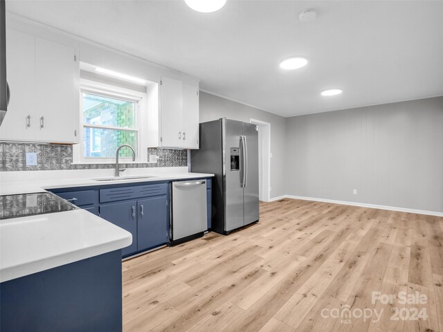 kitchen featuring decorative backsplash, appliances with stainless steel finishes, sink, and white cabinetry