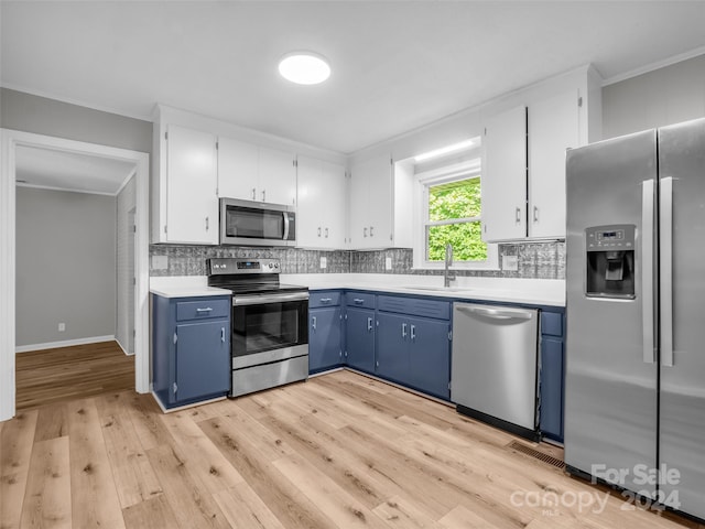 kitchen featuring tasteful backsplash, sink, blue cabinetry, stainless steel appliances, and white cabinets