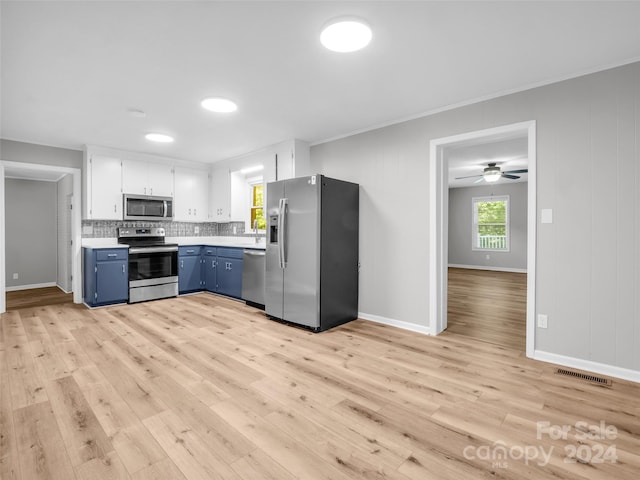 kitchen featuring light wood-type flooring, appliances with stainless steel finishes, backsplash, and white cabinetry