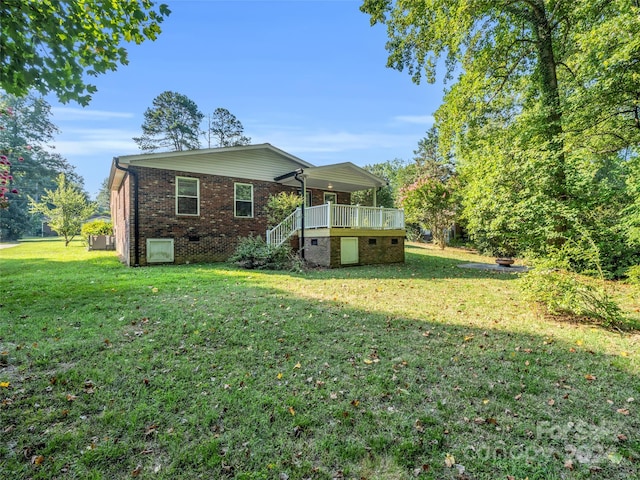 rear view of house with a wooden deck and a yard