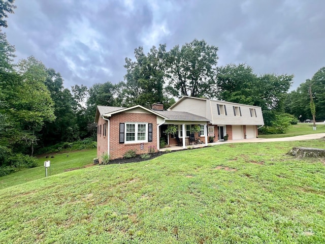 view of front of property featuring a front lawn, covered porch, and a garage