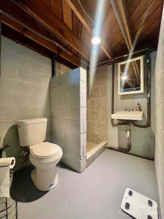 bathroom featuring concrete floors, sink, toilet, and walk in shower