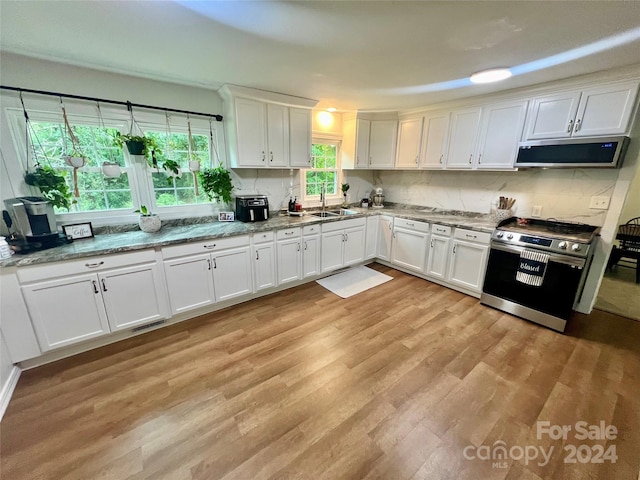 kitchen with light hardwood / wood-style floors, sink, stainless steel appliances, white cabinets, and light stone counters