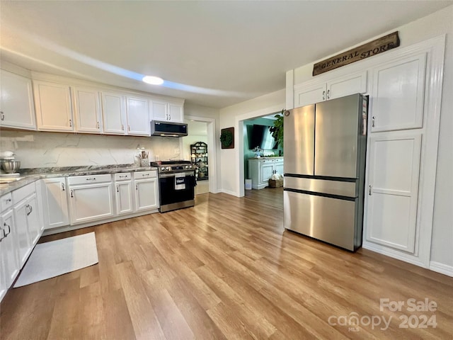 kitchen with decorative backsplash, white cabinetry, appliances with stainless steel finishes, and light hardwood / wood-style flooring