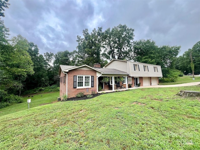 view of front of home featuring a front lawn, a garage, and covered porch