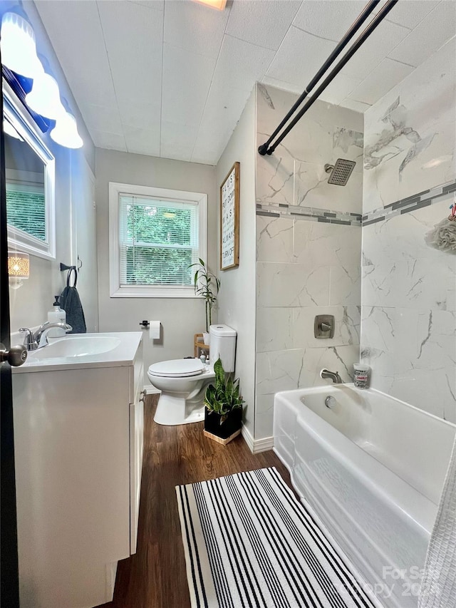 full bathroom with toilet, tiled shower / bath combo, wood-type flooring, and vanity