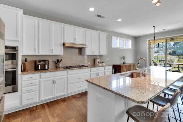 kitchen featuring white cabinetry, appliances with stainless steel finishes, a kitchen island with sink, and sink