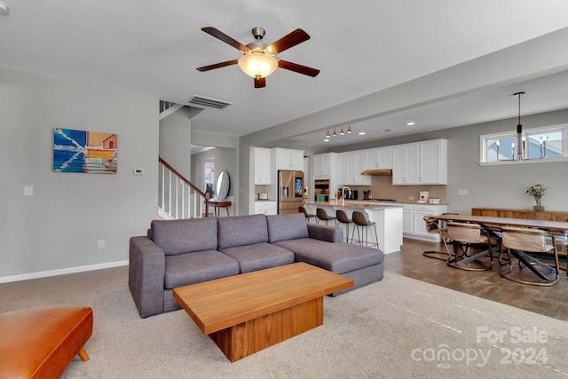 living room with sink and ceiling fan with notable chandelier