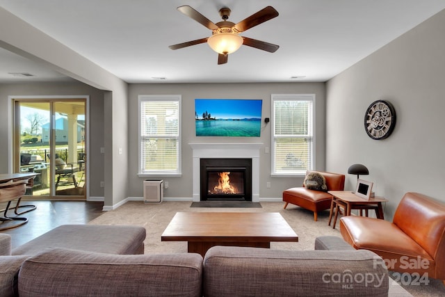 carpeted living room with ceiling fan