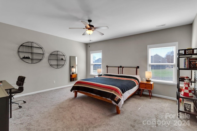 carpeted bedroom with multiple windows and ceiling fan