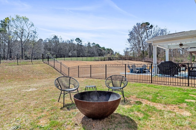 view of yard with ceiling fan and a fire pit