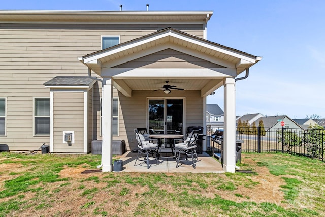 back of property with ceiling fan, a yard, and a patio area