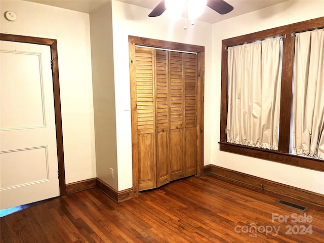 unfurnished bedroom with dark hardwood / wood-style floors, ceiling fan, and a closet