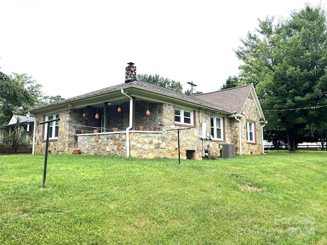 view of side of home with a yard and central AC unit