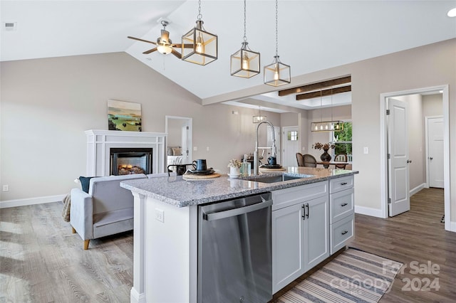 kitchen with stainless steel dishwasher, sink, a kitchen island with sink, and hardwood / wood-style flooring