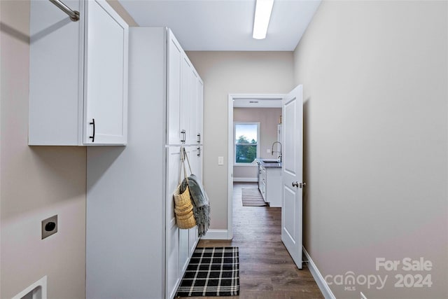 laundry area with sink, electric dryer hookup, dark hardwood / wood-style floors, and cabinets