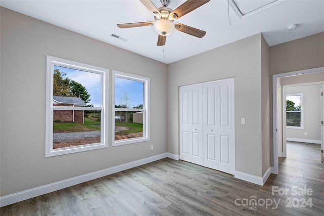 unfurnished bedroom featuring wood-type flooring, a closet, and ceiling fan