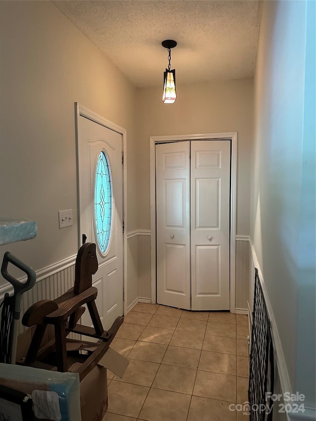 tiled entryway featuring a textured ceiling