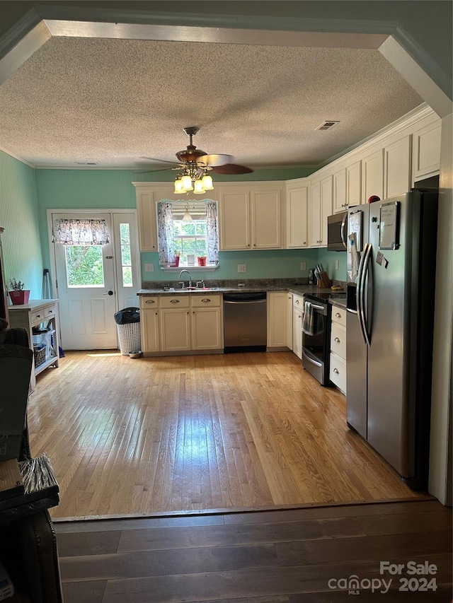 kitchen featuring ceiling fan, stainless steel appliances, a textured ceiling, light hardwood / wood-style flooring, and sink