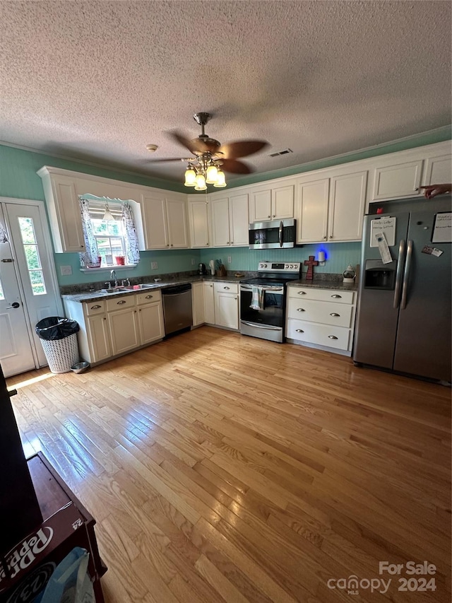 kitchen featuring light hardwood / wood-style floors, a textured ceiling, appliances with stainless steel finishes, and ceiling fan