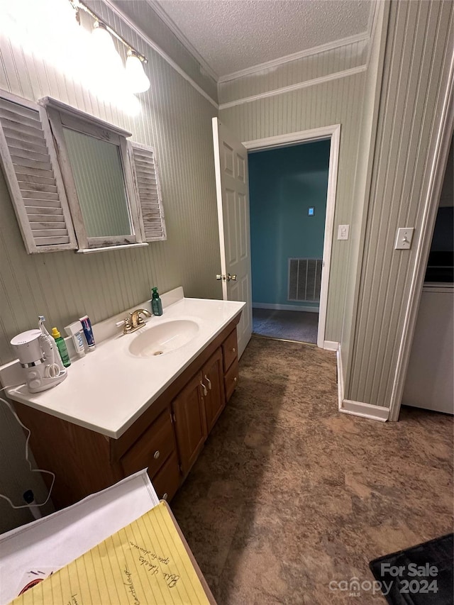 bathroom with a textured ceiling, vanity, crown molding, and wooden walls