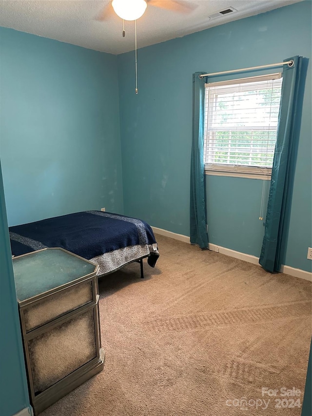 bedroom featuring ceiling fan, carpet, and a textured ceiling