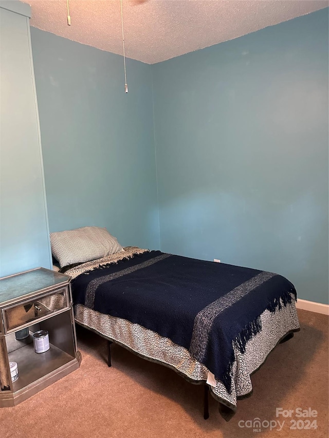 carpeted bedroom featuring a textured ceiling