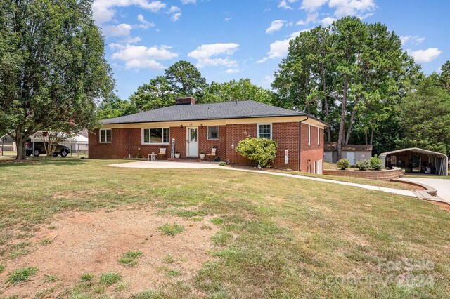 single story home featuring a carport, a patio area, and a front lawn