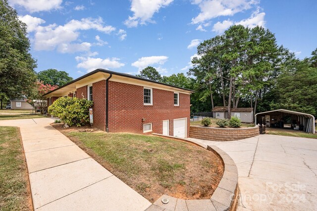 view of home's exterior with a garage and a carport