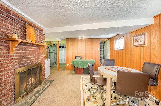 rec room featuring light colored carpet, a brick fireplace, wood walls, and a textured ceiling