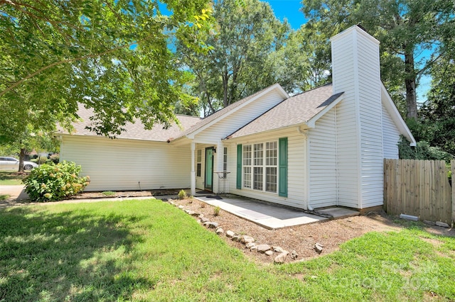 ranch-style home with a front yard and a patio