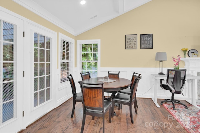 dining room with dark wood-type flooring, ornamental molding, and vaulted ceiling