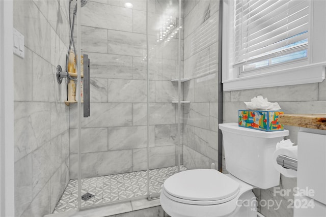 bathroom featuring toilet and a shower with door