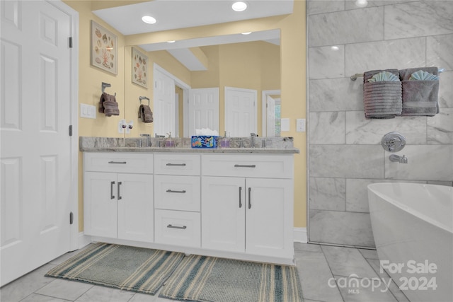 bathroom featuring a tub, vanity, and tile patterned flooring