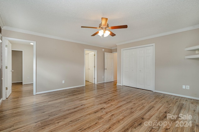 unfurnished bedroom featuring a closet, ceiling fan, ornamental molding, light hardwood / wood-style flooring, and a textured ceiling