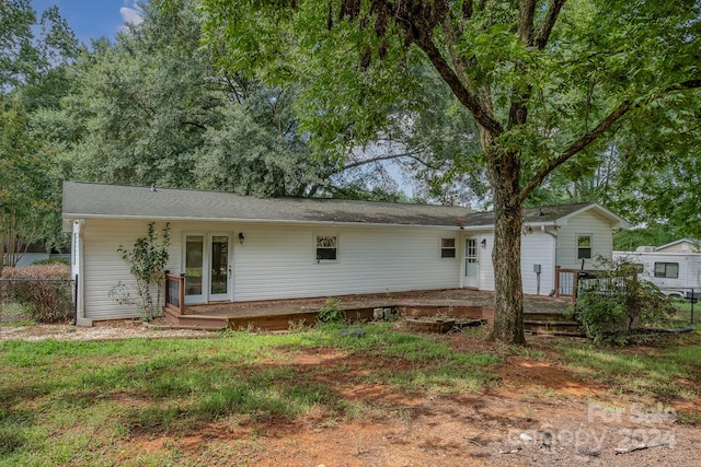 rear view of property with a wooden deck and french doors