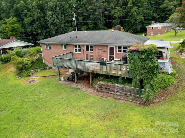 rear view of house featuring a lawn and a deck