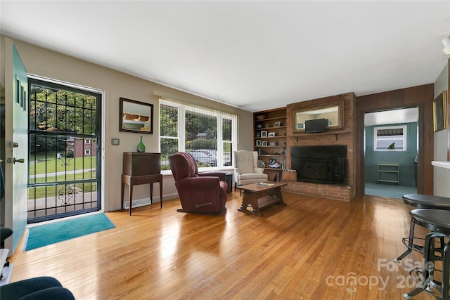 living room featuring light wood-type flooring and built in shelves