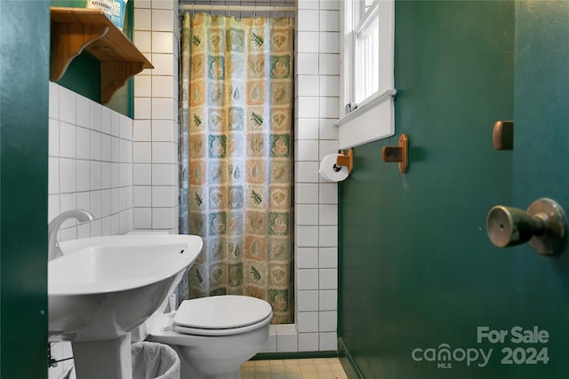 bathroom with tile walls, a shower with curtain, and toilet