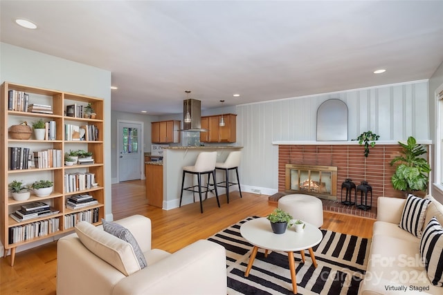 living room featuring wood walls, a fireplace, and light hardwood / wood-style floors