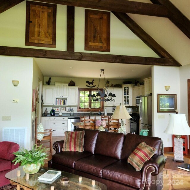 living room with an inviting chandelier and vaulted ceiling with beams