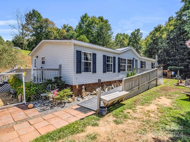 exterior space with a front yard and a wooden deck