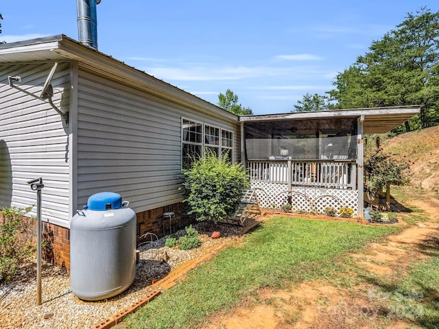 exterior space featuring a sunroom and a lawn