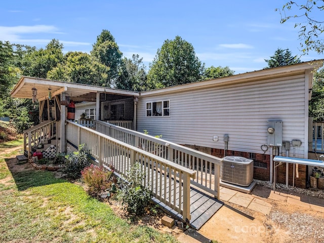 rear view of property with central AC unit and a deck