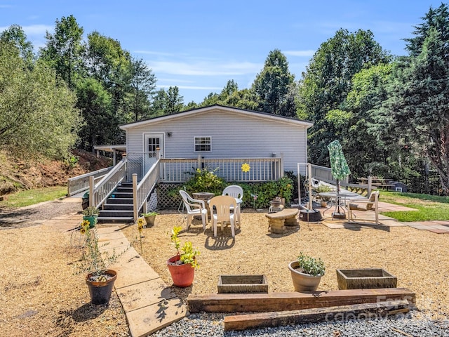 rear view of property with a patio area and an outdoor fire pit