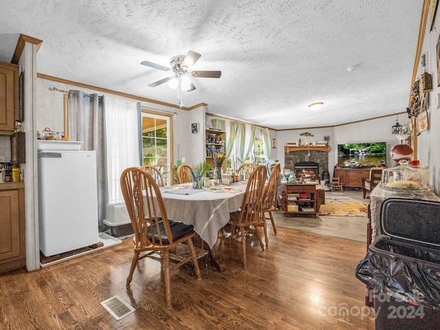 dining room with hardwood / wood-style flooring, plenty of natural light, and ornamental molding