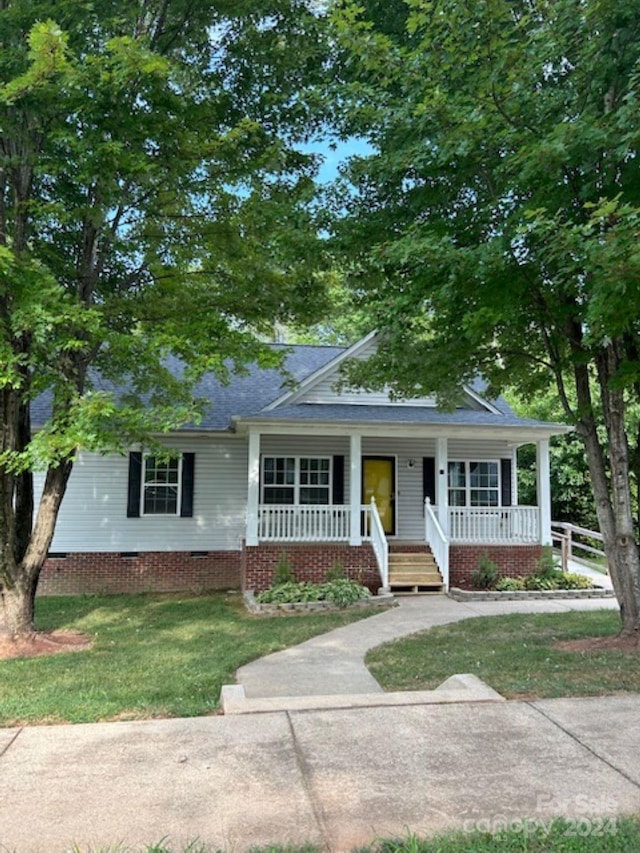 ranch-style home with a porch and a front lawn