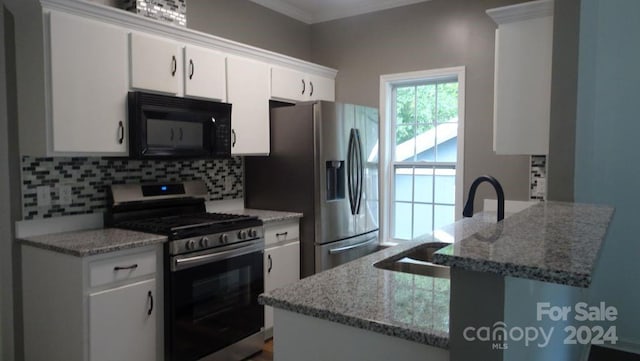 kitchen featuring stainless steel appliances, light stone countertops, white cabinetry, and tasteful backsplash