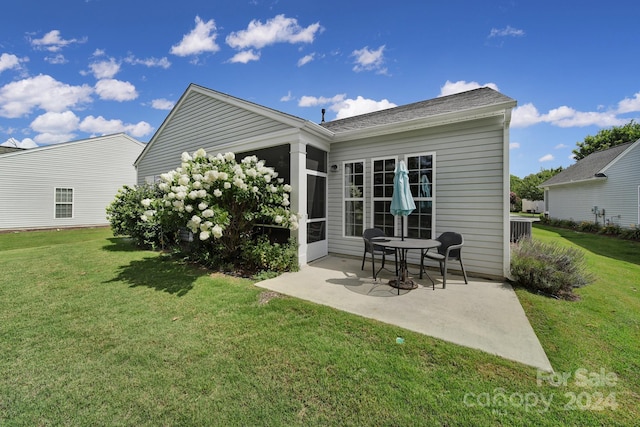 rear view of property featuring a yard and a patio